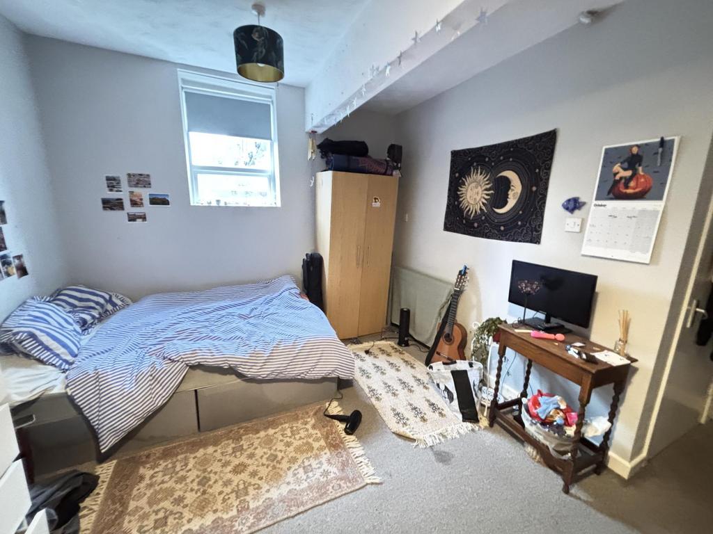 A cozy bedroom featuring a comfortable bed, som...