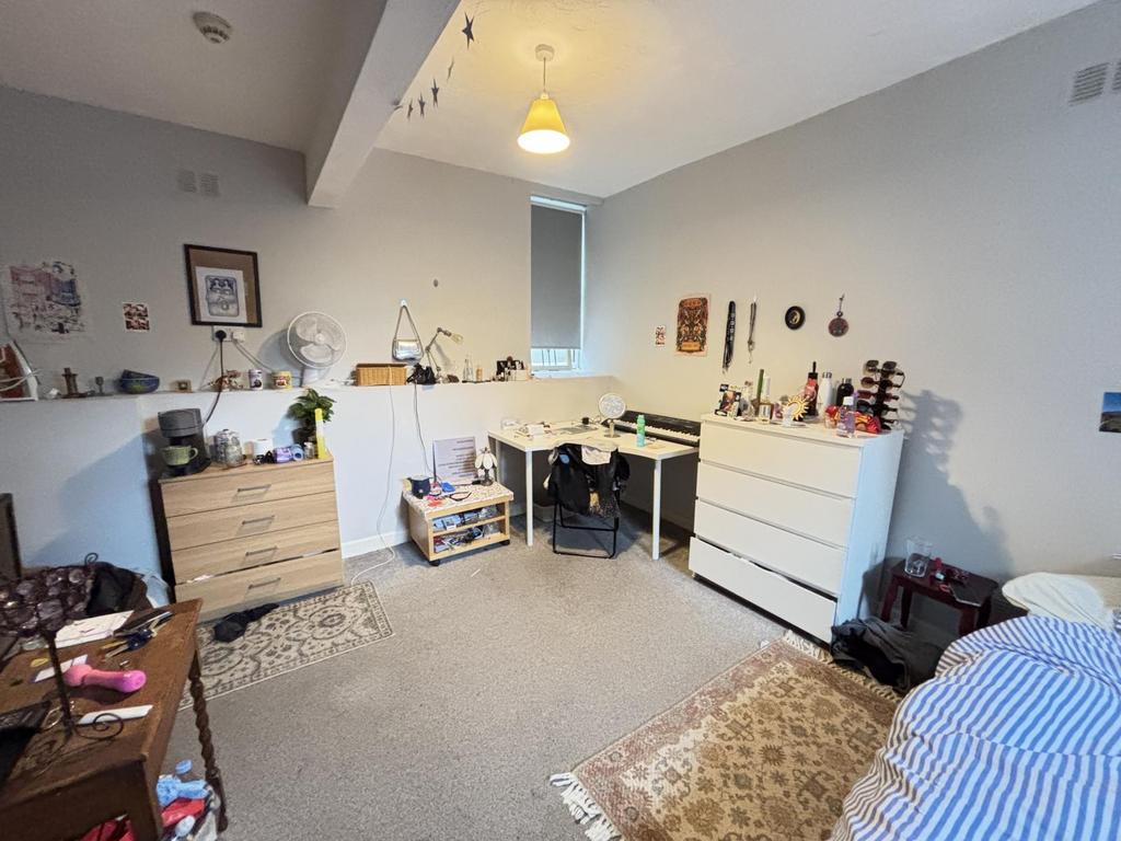 A cozy bedroom featuring a double bed with a sm...