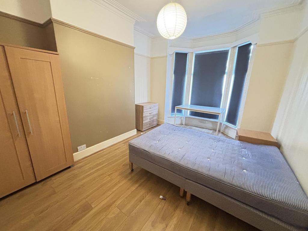 A bright and spacious bedroom featuring large w...