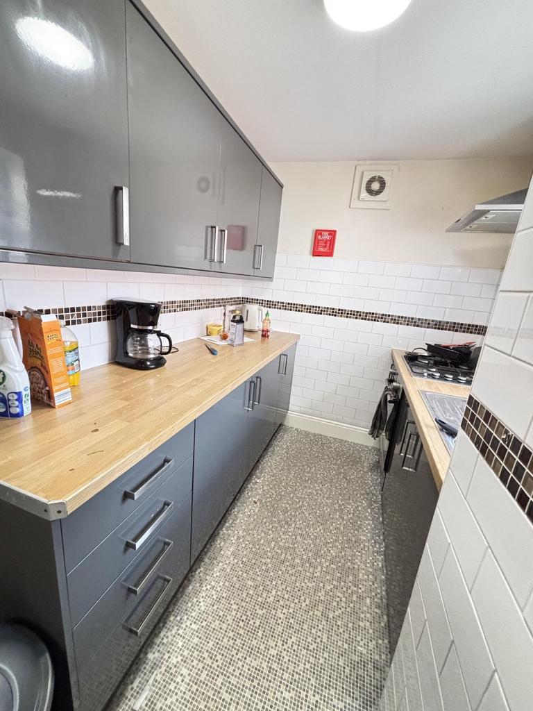 A tidy, well-maintained kitchen with modern gre...