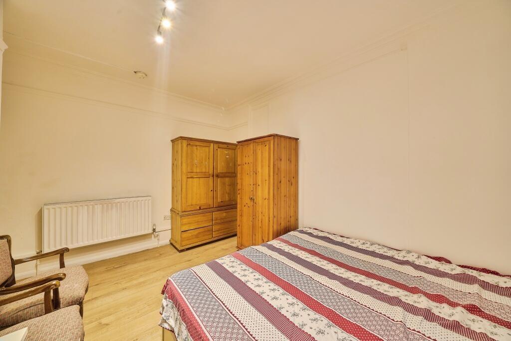 Bright double bedroom with wooden flooring, mat...