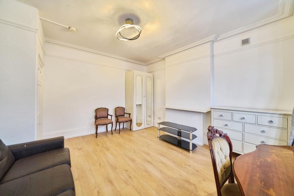 Bright, neutral living room with light wood flo...