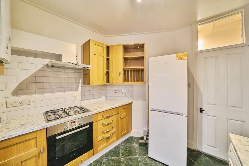Bright fitted kitchen with wooden cabinets, mar...