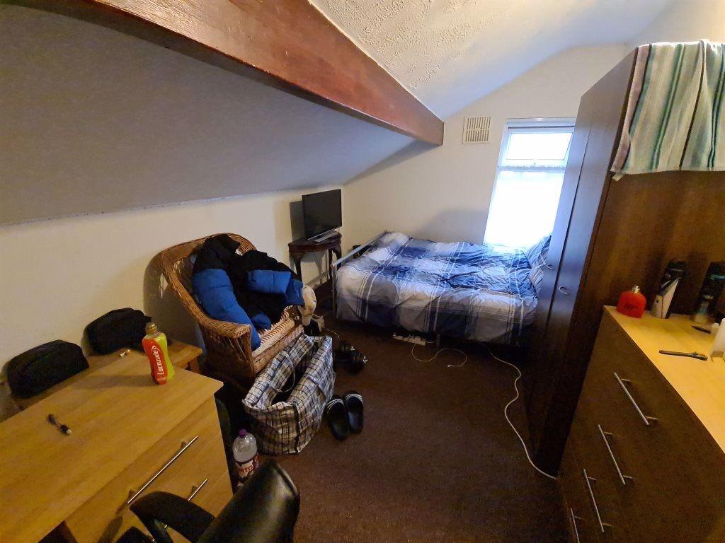 Cozy single bedroom featuring a comfortable bed...