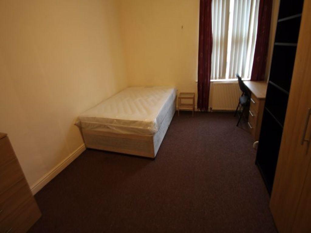 A simple, tidy single bedroom with a large wind...
