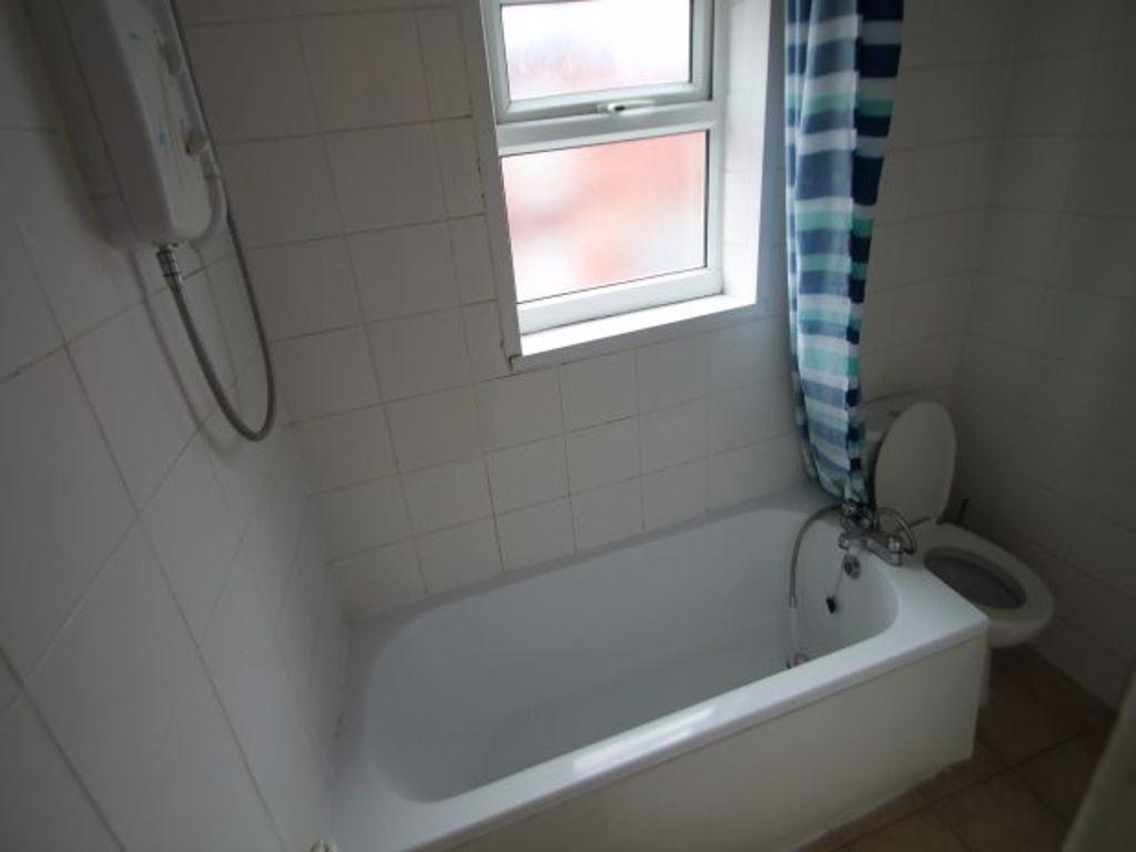 A bright bathroom suite featuring a white batht...