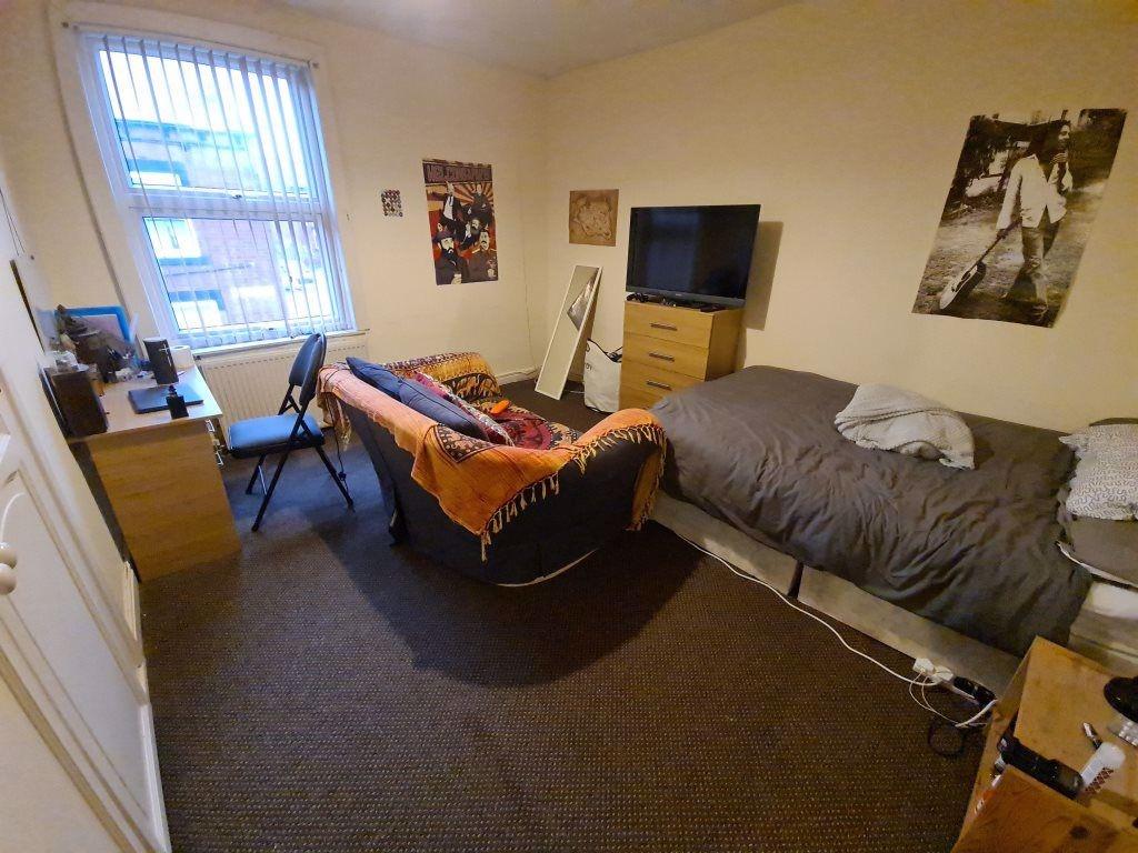 A cozy student bedroom featuring a single bed a...