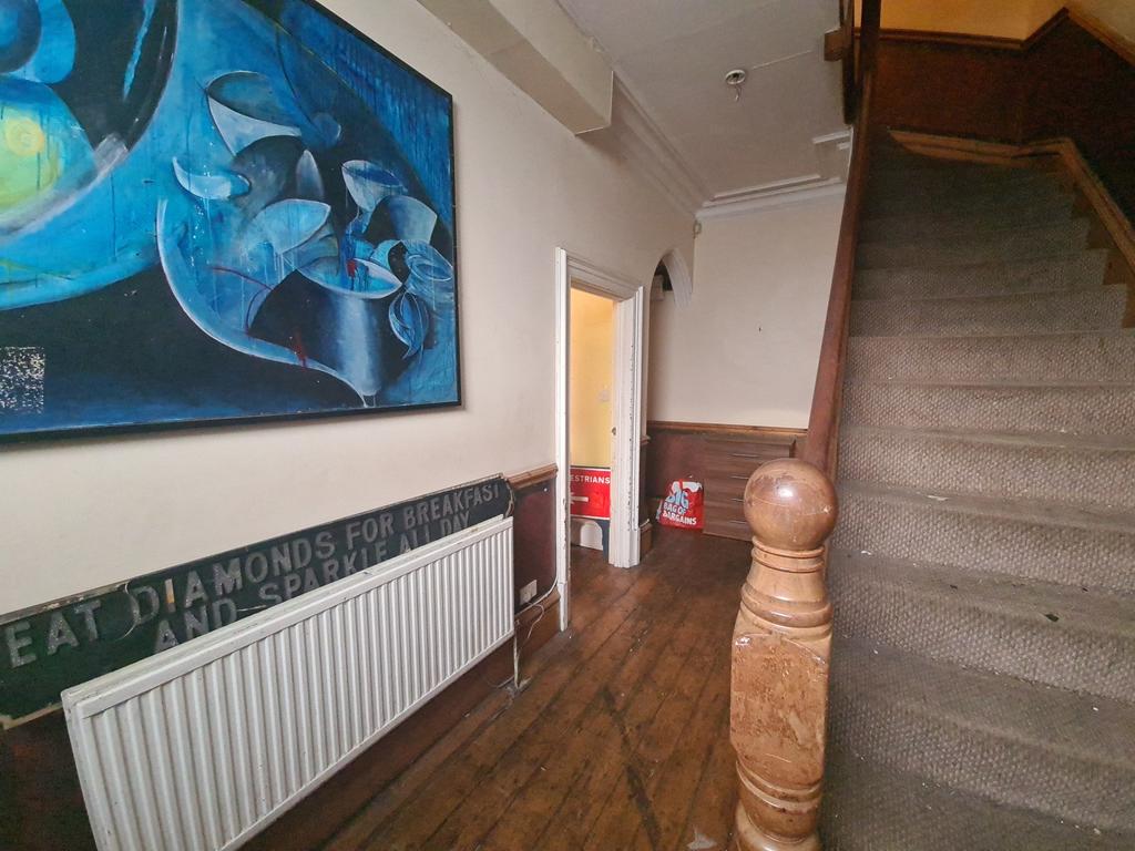 A welcoming hallway featuring warm wooden floor...