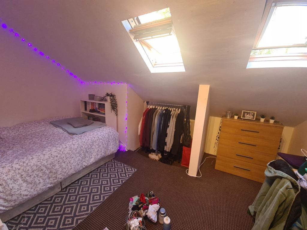 Bright and cozy attic bedroom featuring two sky...