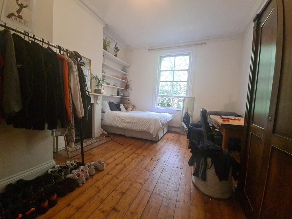 A cozy and neatly organized bedroom featuring a...
