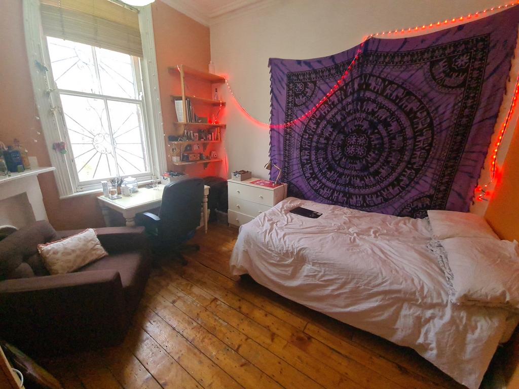A cozy single bedroom with a comfortable bed, a...