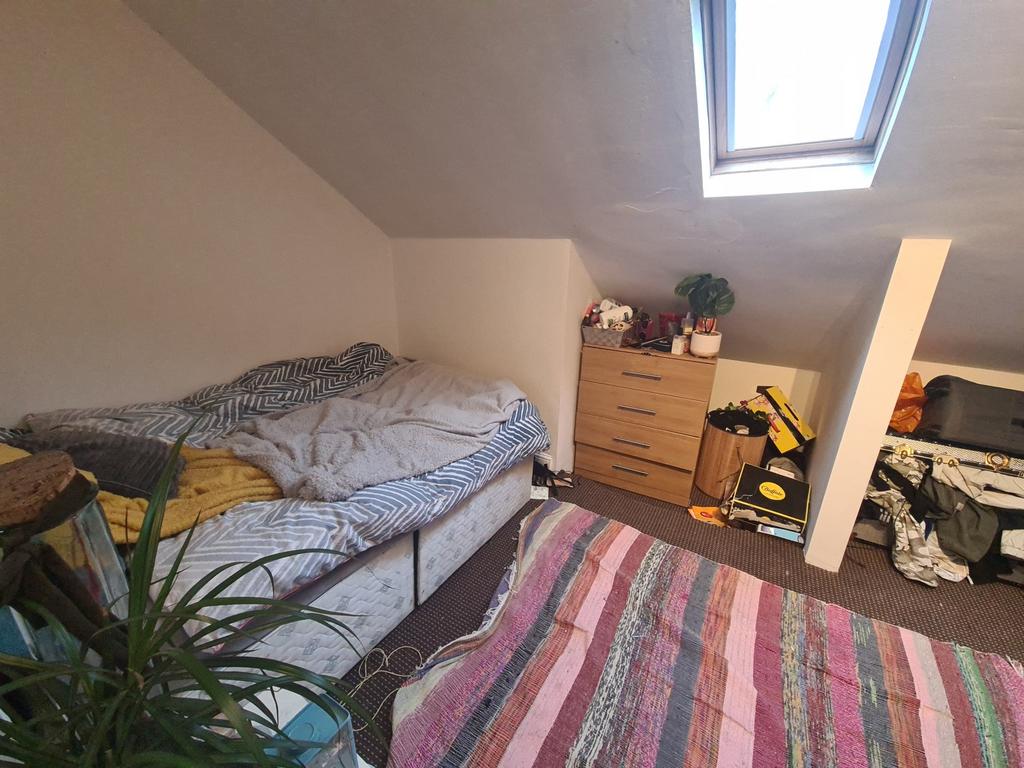 Cozy bedroom featuring a skylight that provides...