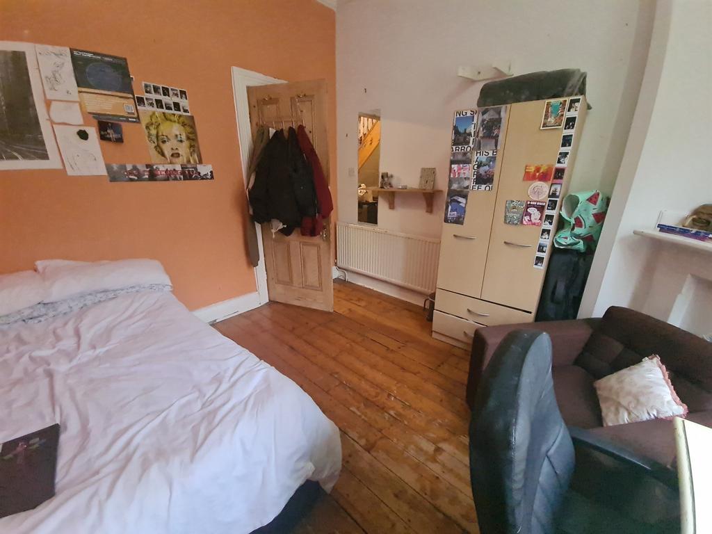 A cozy double bedroom with warm wooden flooring...
