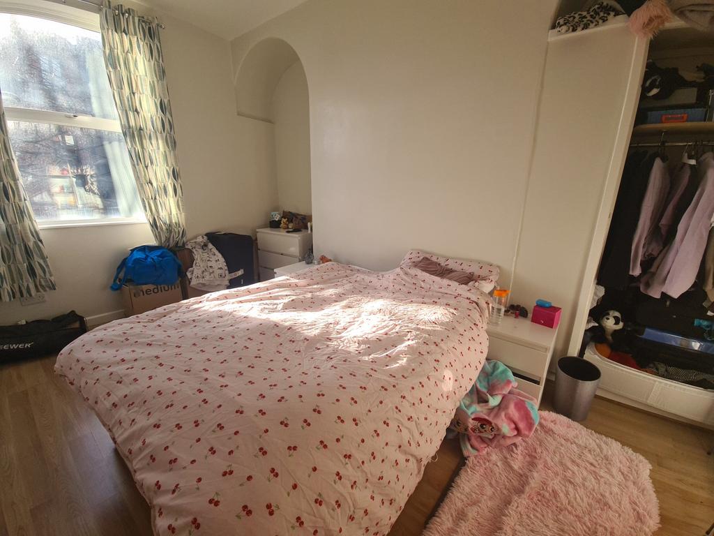 A bright double bedroom featuring a large windo...