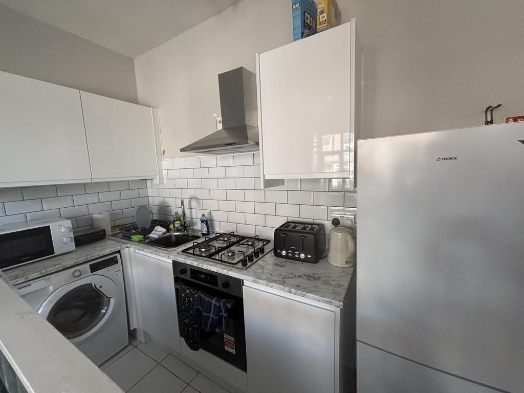 A modern kitchen with white cabinets, a stove, ...
