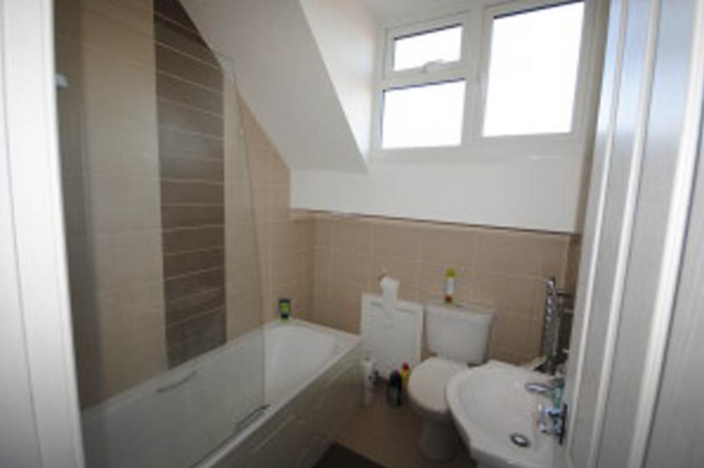 A tidy bathroom with a bathtub, toilet, and sma...
