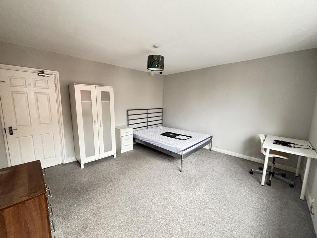 A clean, well-lit bedroom with ample space, fea...