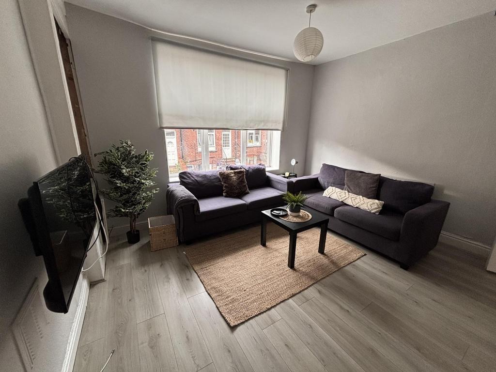 Bright and spacious living room featuring large...