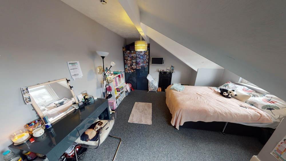 A neatly kept bedroom with a single bed and a s...
