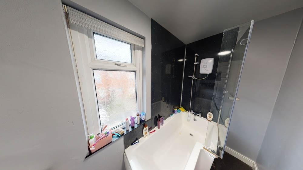 Bright and clean bathroom featuring a white bat...