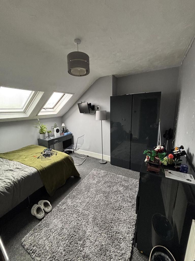 A cozy and well-lit bedroom with skylight windo...