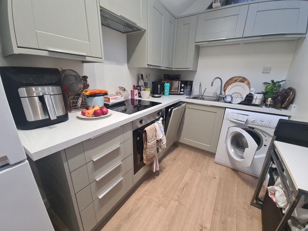 Modern U-shaped kitchen with pale cabinetry, in...
