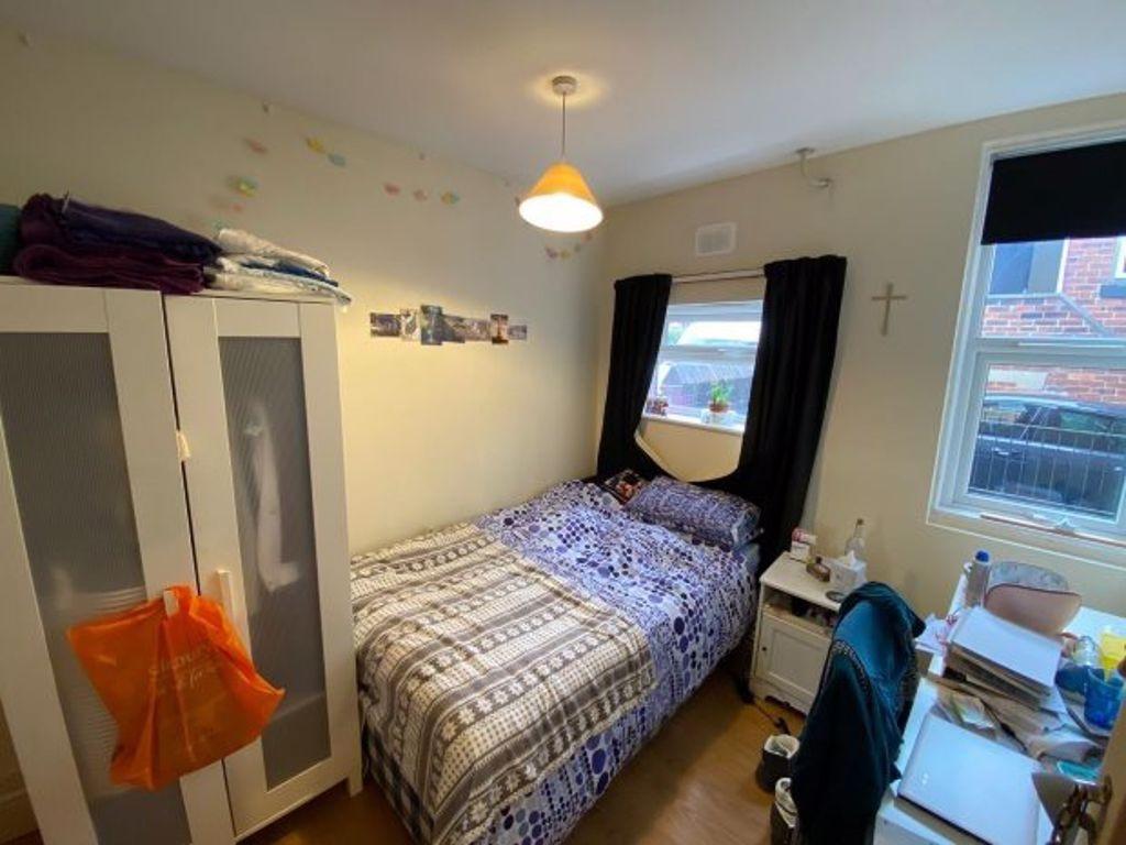 Cozy single bedroom featuring a neatly made bed...