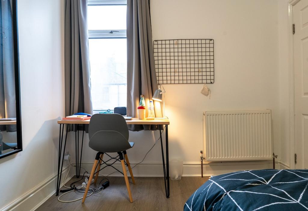 A cozy double bedroom featuring a well-lit stud...