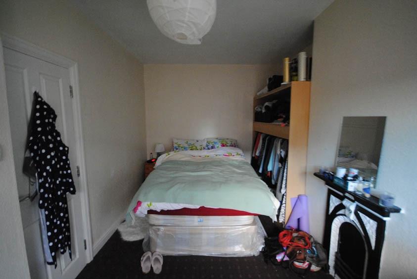 A cozy single bedroom featuring a neatly made b...