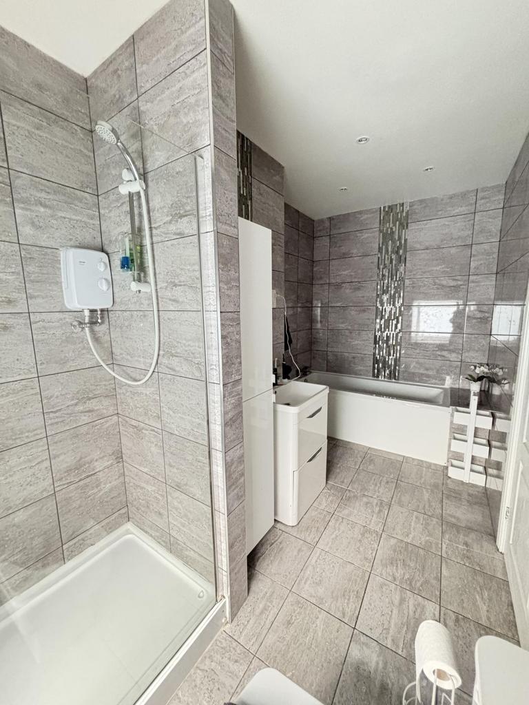 Modern and clean bathroom featuring a shower, b...