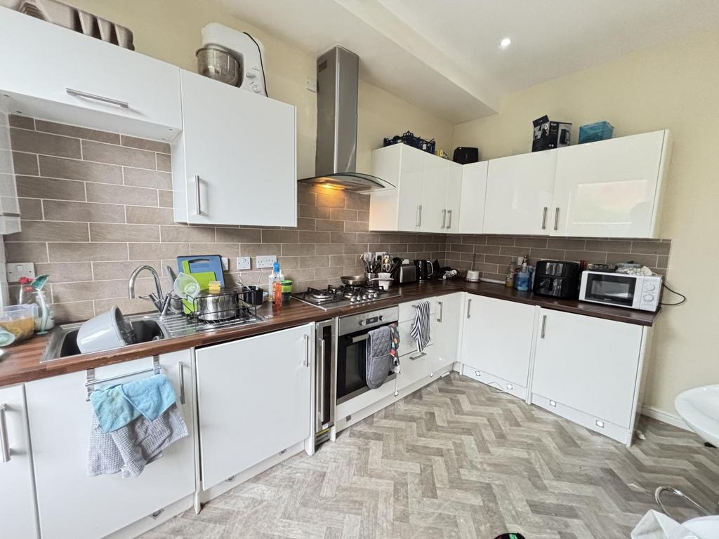 Bright and clean kitchen with ample white cabin...