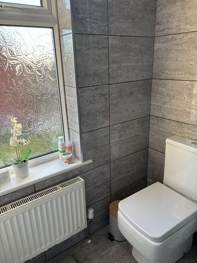 A modern bathroom featuring a clean toilet, a f...