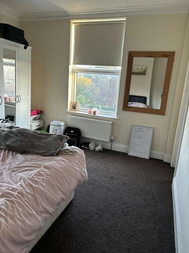 A cozy bedroom featuring a double bed with soft...