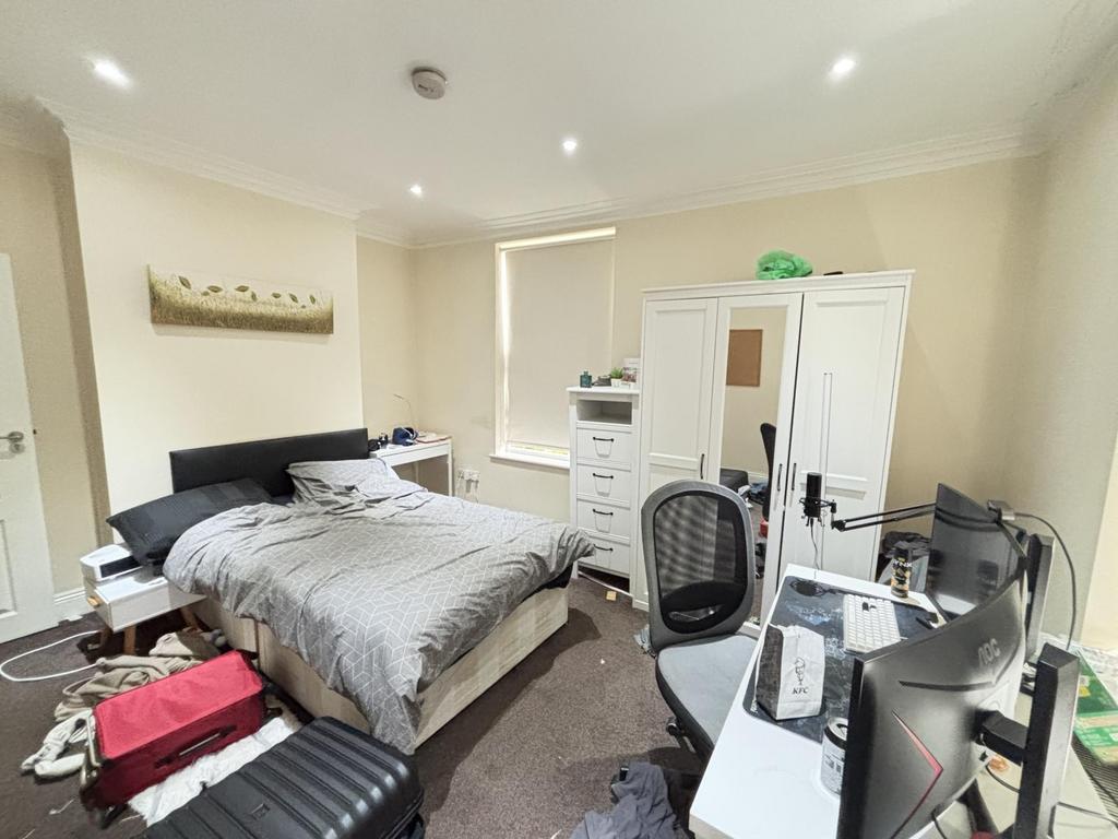 A well-lit, tidy bedroom featuring a double bed...
