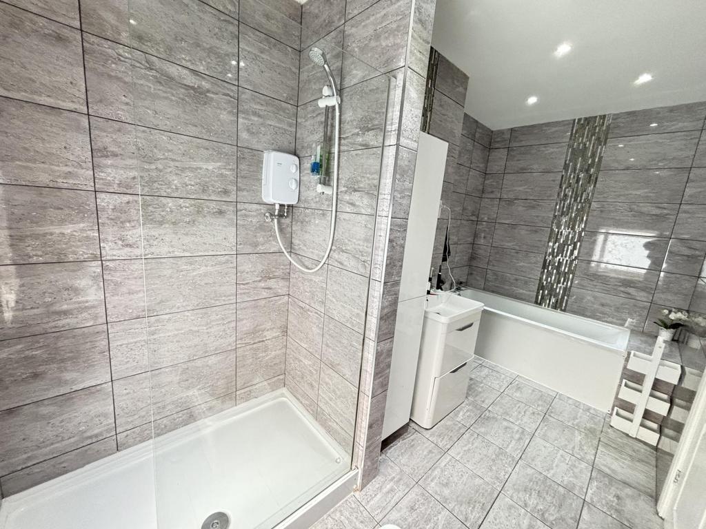 A modern and clean bathroom featuring a bathtub...