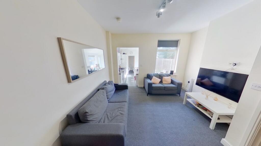 Bright, neutrally decorated living room with tw...