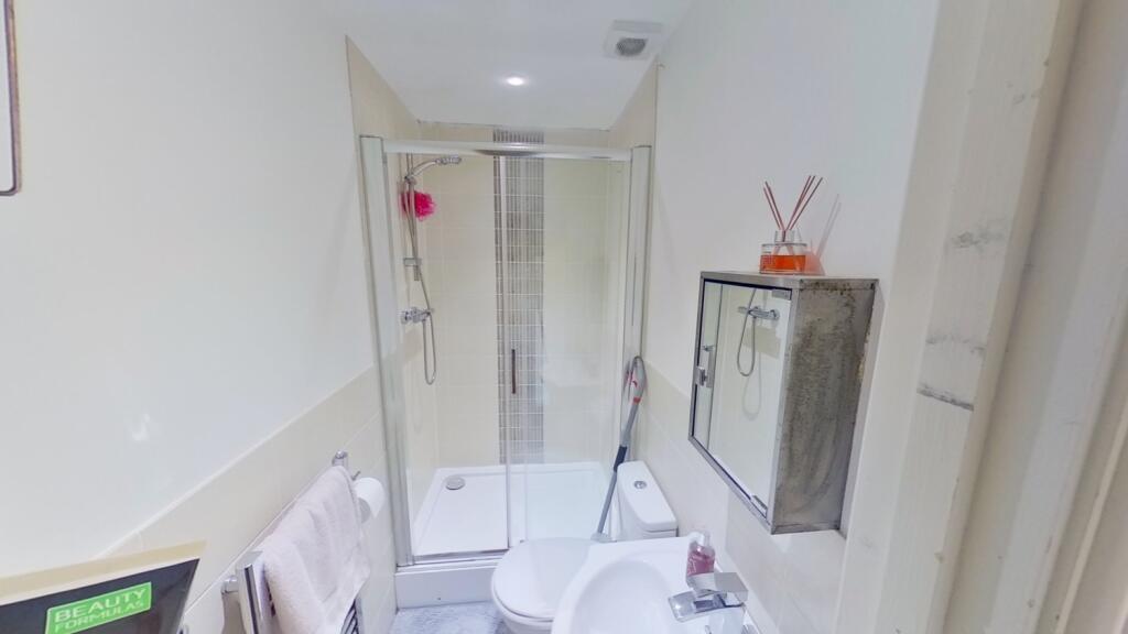 Bright, modern bathroom with a corner glass sho...