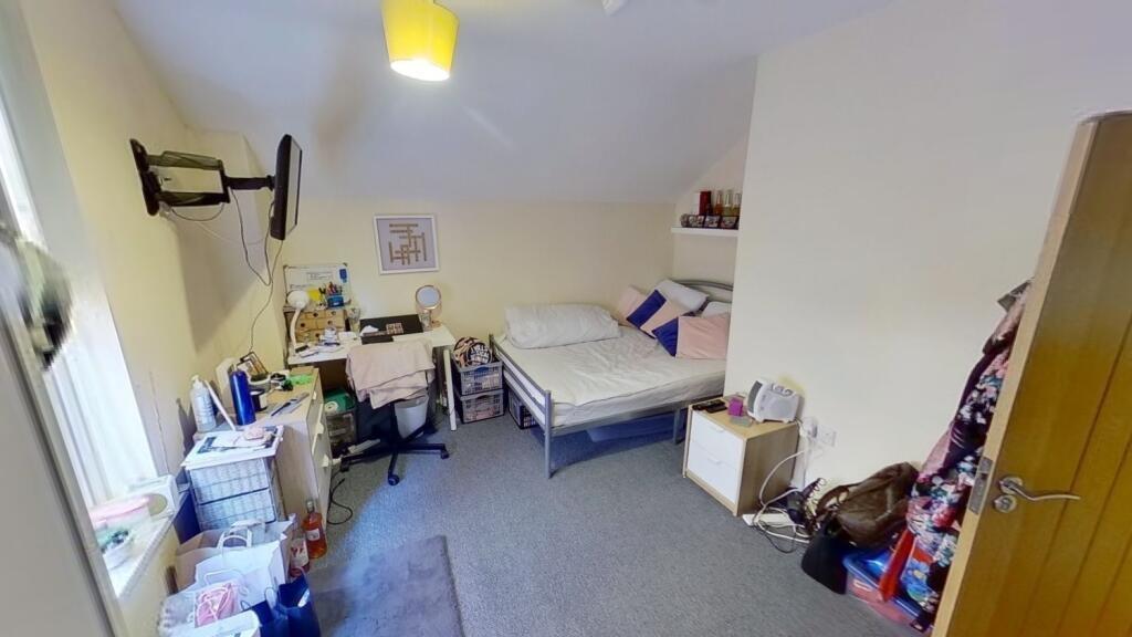 Bright furnished bedroom with a double bed, stu...