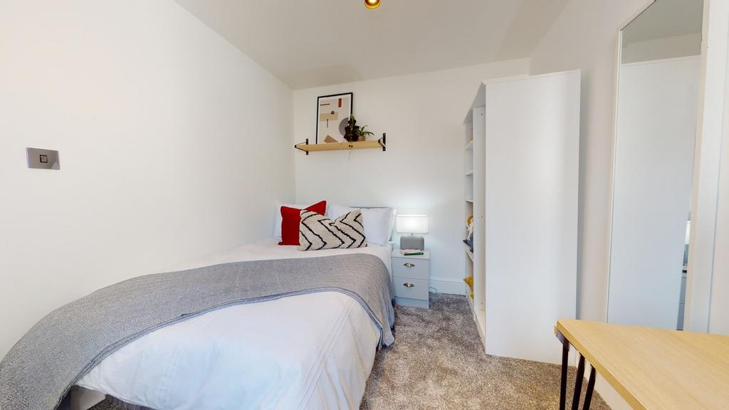 A bright and cozy double bedroom featuring mode...