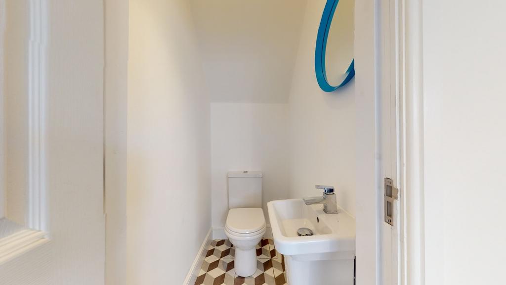 A clean and tidy single toilet with modern fixt...
