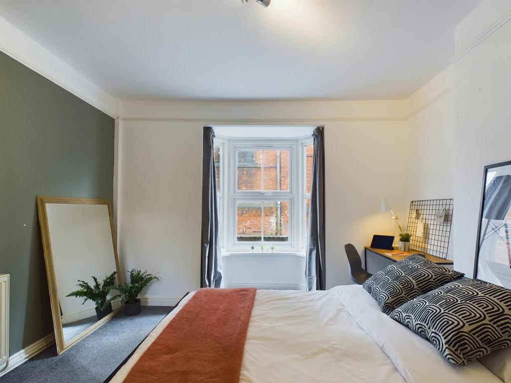 A bright and inviting double bedroom featuring ...