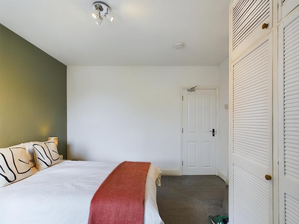 A spacious and inviting double bedroom with a m...