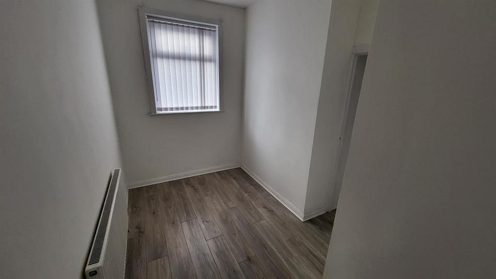 Neat, narrow room with wood-effect flooring, fr...