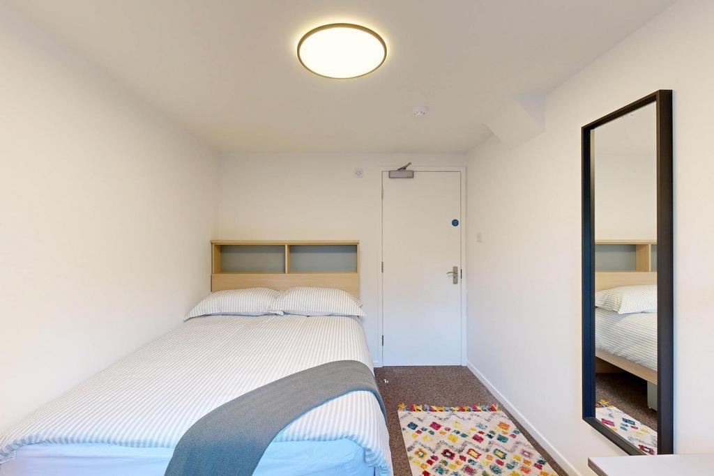 Bright, simply furnished bedroom with a comfort...
