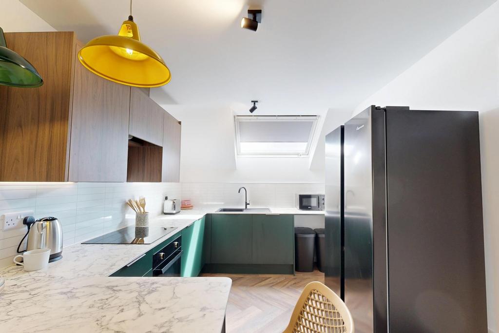 Modern fitted kitchen with marble-effect workto...