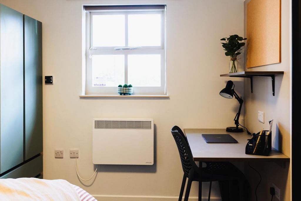 Bright, neatly arranged bedroom with a large wi...