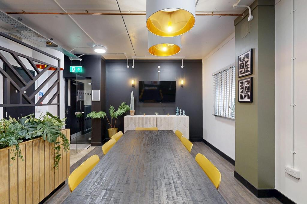 Bright, modern communal workspace with a long m...