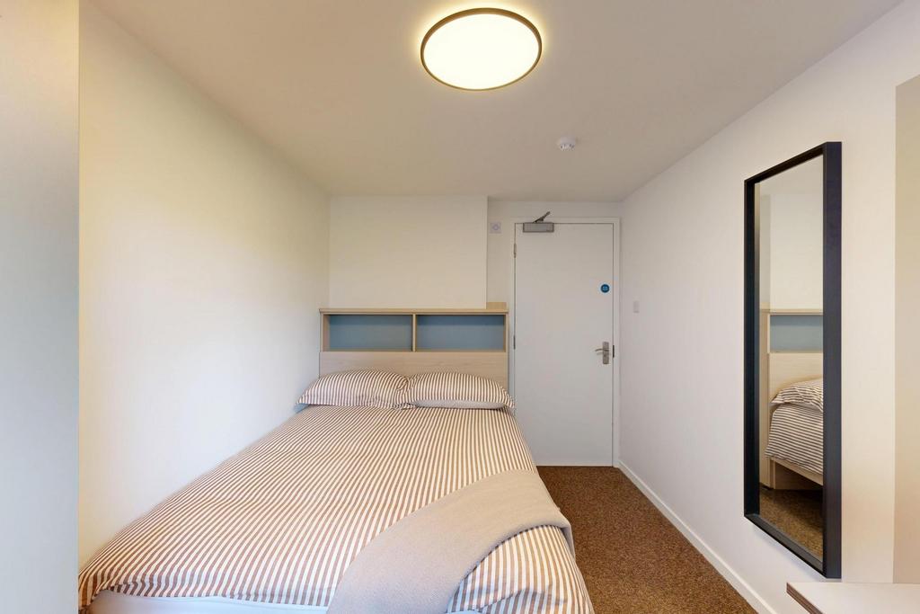 Bright, simply furnished bedroom with a comfort...