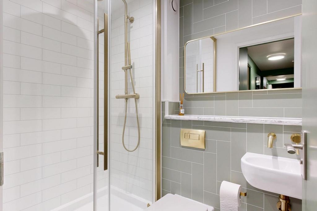Modern bathroom with a glass-enclosed shower, w...