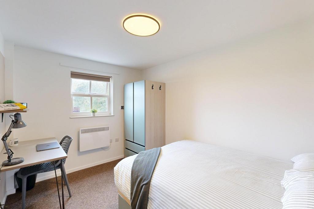 Bright, neatly furnished double bedroom with a ...